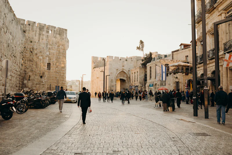People walking beside the Old City walls near Jaffa Gate in Jerusalem